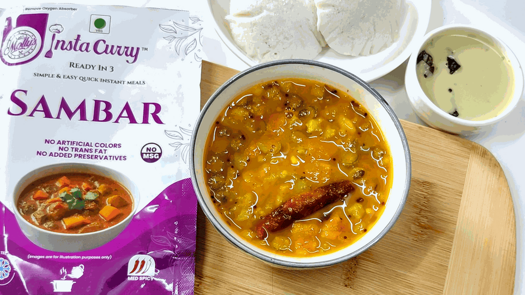 Molly's Insta Curry® Sambar instant meal packet beside golden lentil stew with vegetables and a cinnamon stick