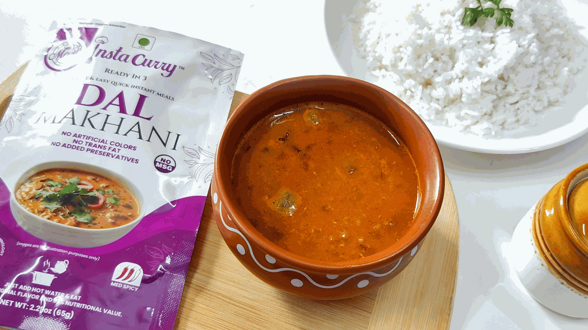 Tawa Pulao meal pouch beside orange lentil curry in a brown ceramic bowl and a plate of white rice
